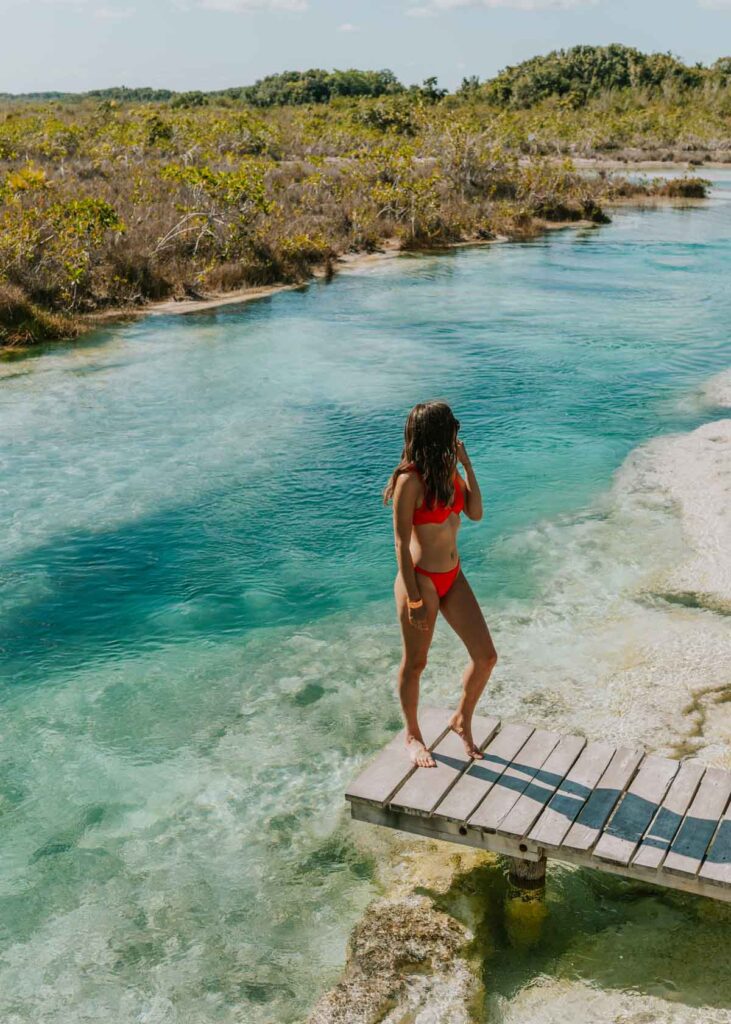 Standing on a wooden dock at Bacalar's Los Rapidos