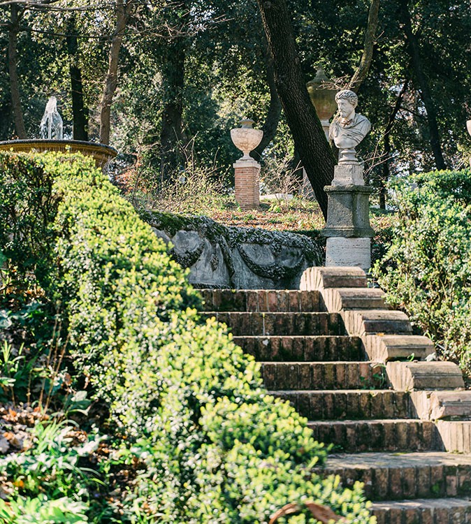 stone steps and statues surrounded by greenery
