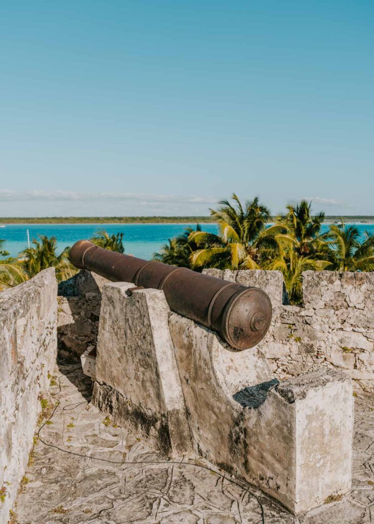 A canon at Fuerte de San Felipe Bacalar overlooking the blue Bacalar lagoon