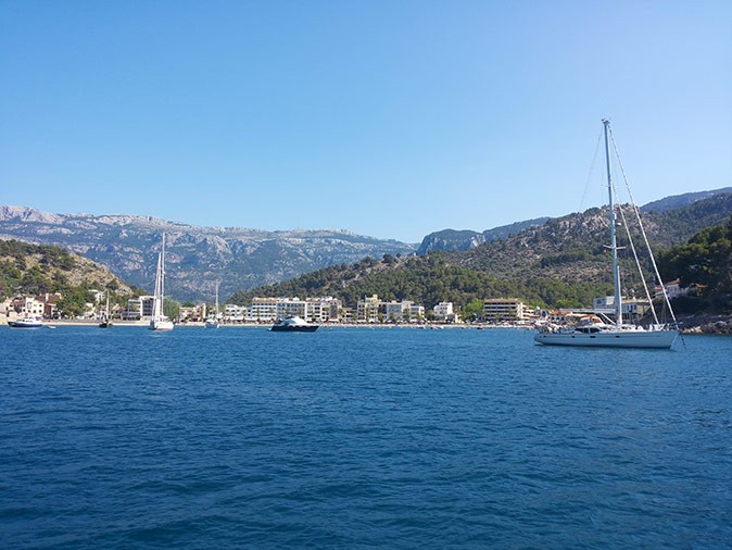 A wide bay with several boats and mountains in the background