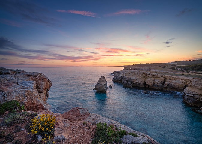 a beautiful sunset with brown cliffs and blue water