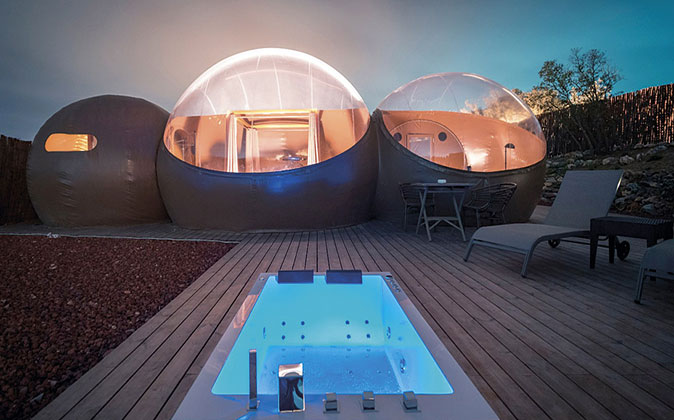 three bubble shaped rooms with a hot tub in front of it