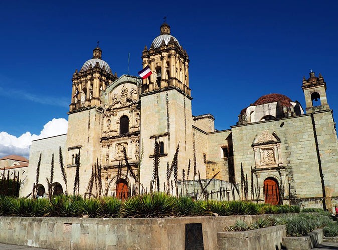 A brown stone church in Oaxaca with a bright blue sky