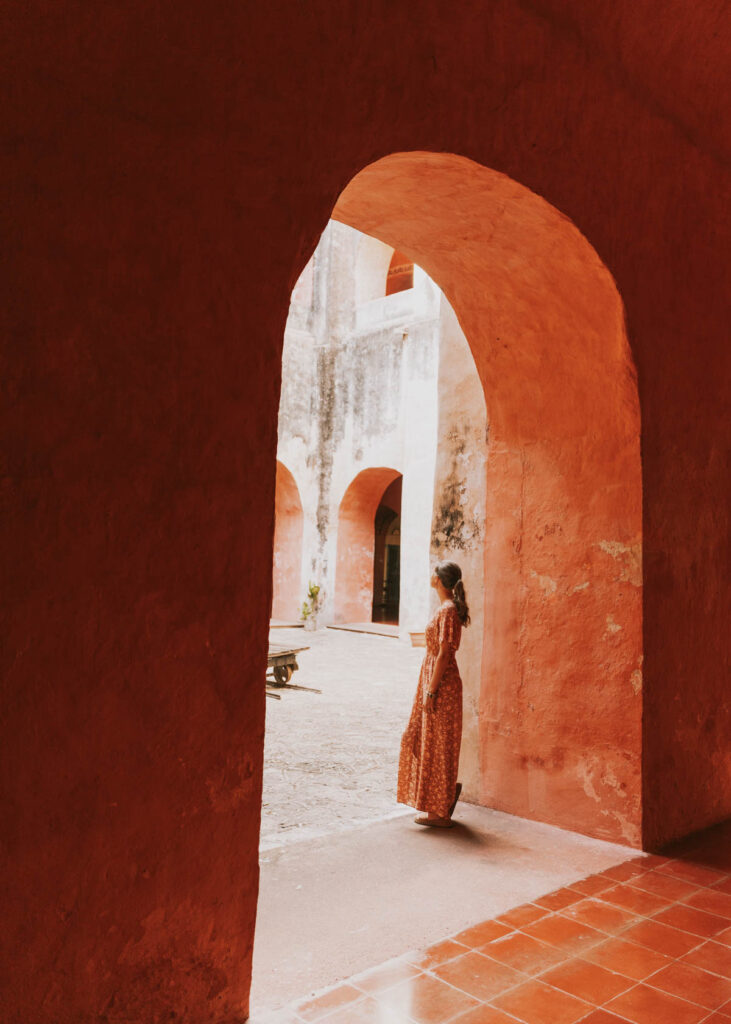 Woman standing beneath pink archway at Convento de San Bernardino de Siena, a must visit spot on this Valladolid itinerary 