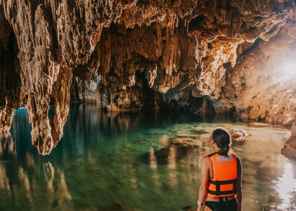Woman standing in front of cave formations in one of Valladolid's cenotes