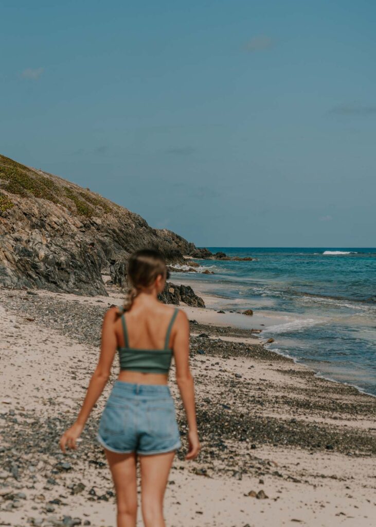 Woman walking along beach on St Croix USVI, photo for island instagram captions
