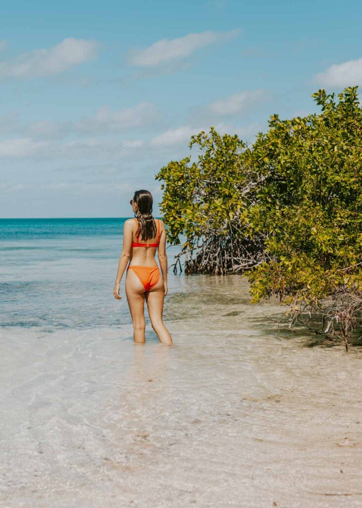 Woman walking through the water on Caye Caulker island in Belize