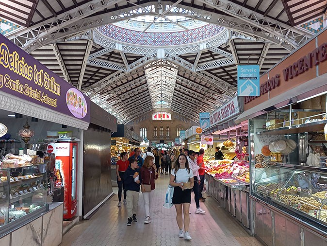 Several people walking inside an indoor market