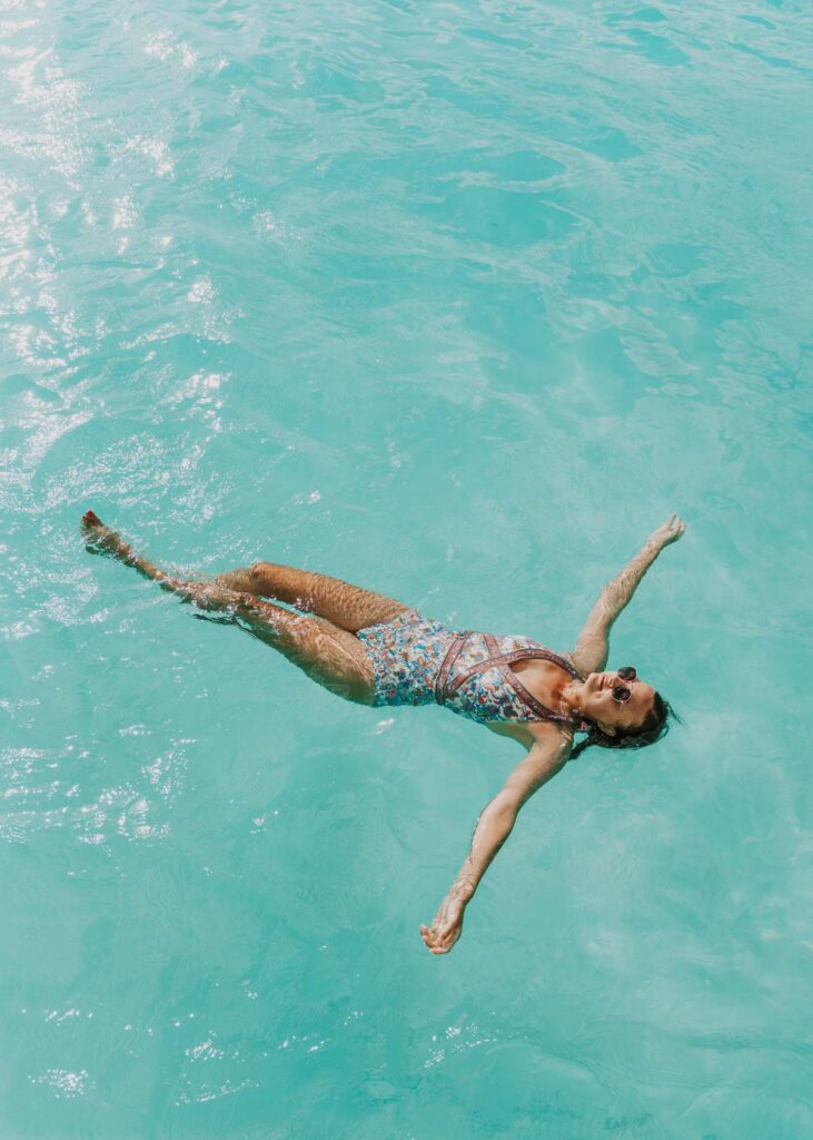 Woman floating in turquoise blue water in Bacalar, a Cancun day trip idea
