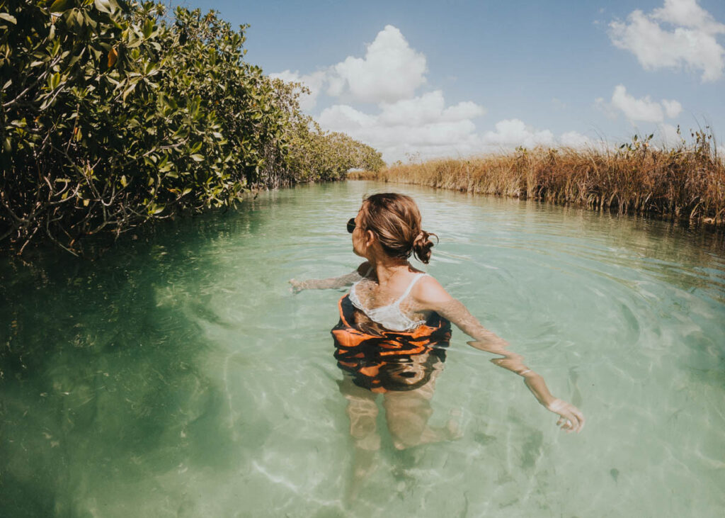 Woman standing in shallow water at the Muyil River Float, a perfect day trip from Cancun